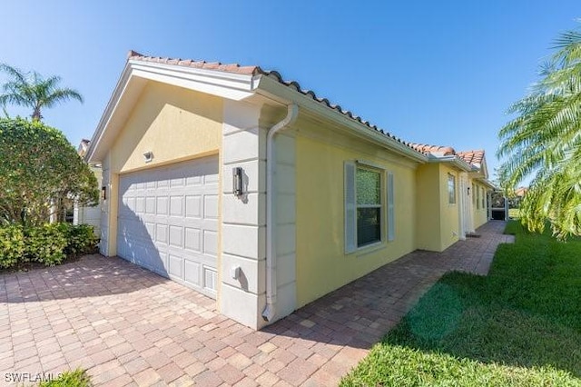 view of property exterior featuring a tiled roof and stucco siding