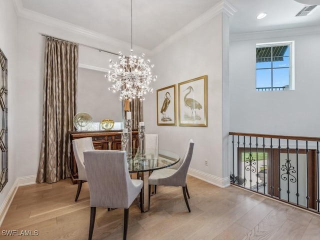 dining room featuring crown molding, wood finished floors, visible vents, and baseboards