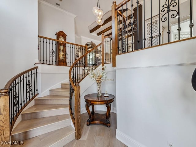 staircase featuring baseboards and wood finished floors