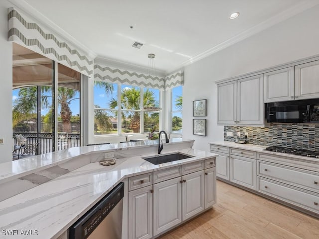 kitchen with gas cooktop, a sink, black microwave, stainless steel dishwasher, and crown molding