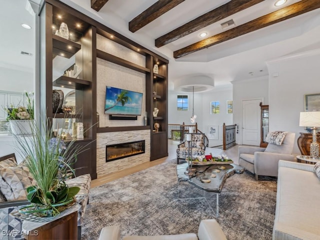 living room with beam ceiling, built in features, visible vents, and a glass covered fireplace