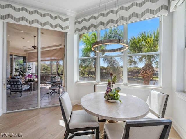 dining room featuring baseboards, light wood-style floors, and crown molding