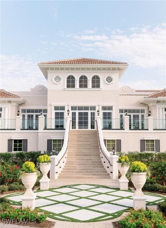 back of property featuring stucco siding and stairs