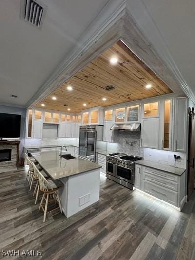 kitchen featuring white cabinetry, fridge, visible vents, and double oven range