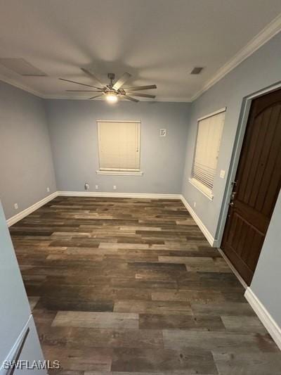 unfurnished room featuring crown molding, baseboards, and wood finished floors