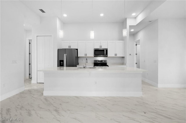 kitchen featuring visible vents, white cabinets, marble finish floor, stainless steel appliances, and a sink