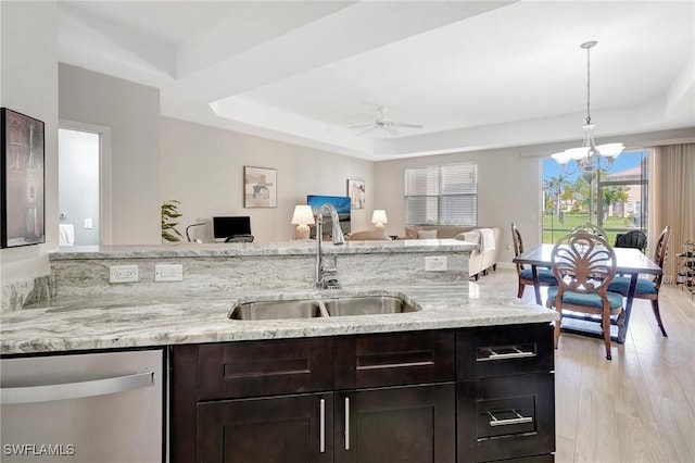 kitchen featuring dishwasher, a tray ceiling, open floor plan, and a sink