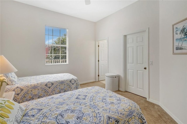 bedroom featuring light colored carpet, baseboards, and ceiling fan