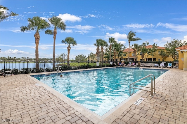 pool with a patio area and fence