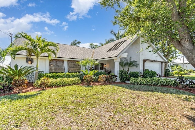 ranch-style home featuring stucco siding, a garage, and a front lawn