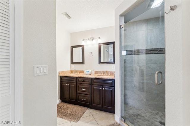 full bathroom featuring a shower stall, double vanity, visible vents, and a sink