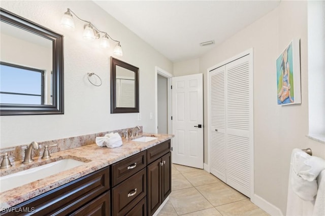 bathroom with a sink, visible vents, double vanity, and tile patterned floors