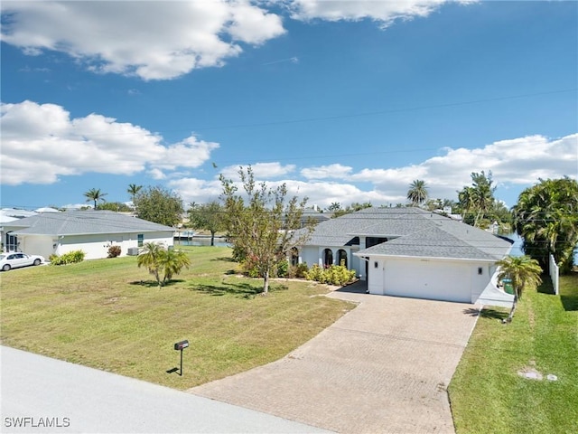 single story home with a front yard, decorative driveway, and an attached garage