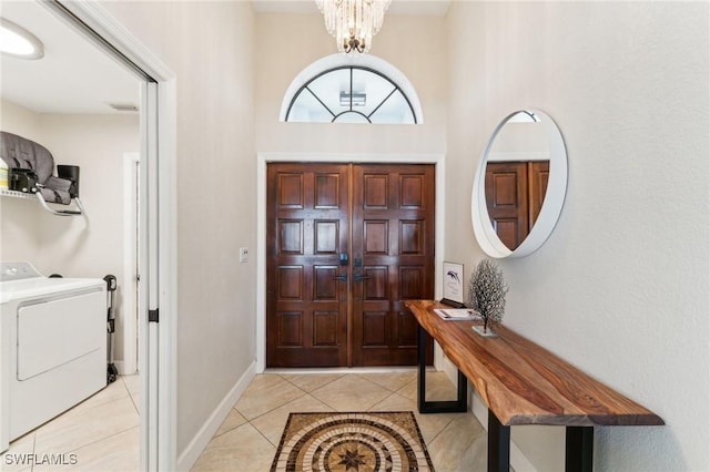 entrance foyer featuring visible vents, baseboards, light tile patterned floors, an inviting chandelier, and washer / clothes dryer