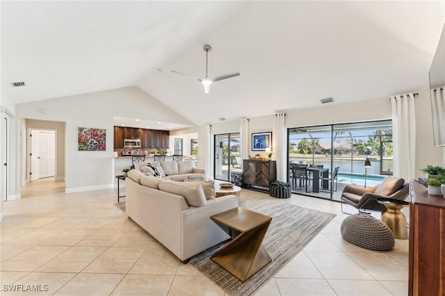 living room with light tile patterned floors, visible vents, high vaulted ceiling, and ceiling fan