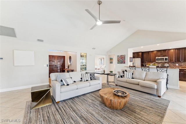 living area featuring high vaulted ceiling, light tile patterned floors, visible vents, and ceiling fan