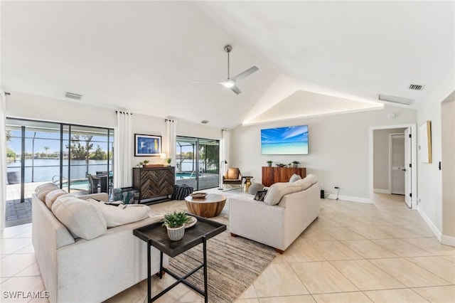 living area featuring a ceiling fan, visible vents, lofted ceiling, light tile patterned flooring, and a water view