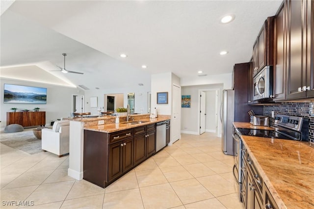 kitchen with light tile patterned floors, open floor plan, appliances with stainless steel finishes, and a sink