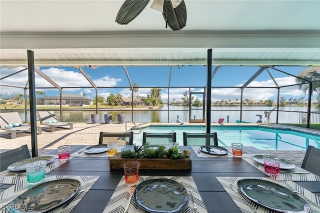 outdoor pool with outdoor dining area, a water view, a patio, and a lanai