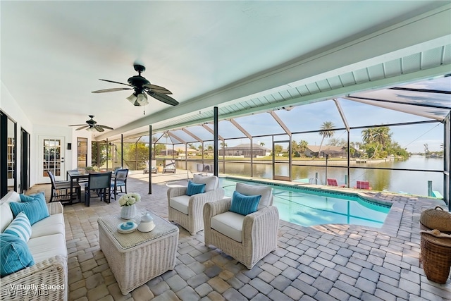 outdoor pool featuring ceiling fan, a water view, a lanai, a patio area, and an outdoor hangout area