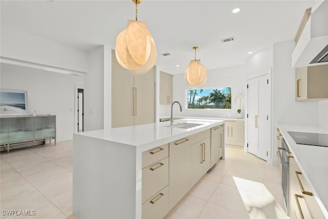 kitchen featuring visible vents, light countertops, wall chimney range hood, a sink, and recessed lighting