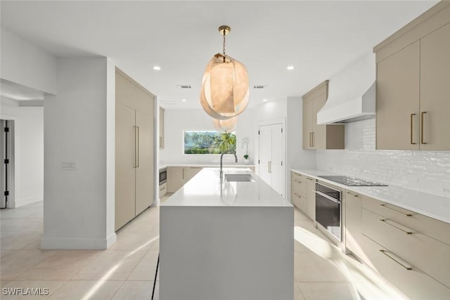 kitchen with backsplash, oven, black electric stovetop, premium range hood, and a sink