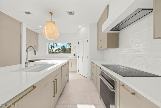 kitchen featuring visible vents, a sink, black electric cooktop, oven, and exhaust hood