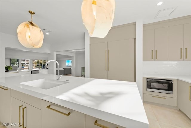 kitchen featuring light countertops, modern cabinets, a sink, and built in microwave