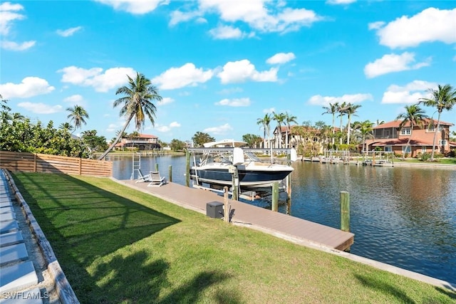 view of dock with a lawn, a water view, boat lift, and fence