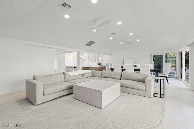 living room with lofted ceiling, visible vents, recessed lighting, and light tile patterned floors