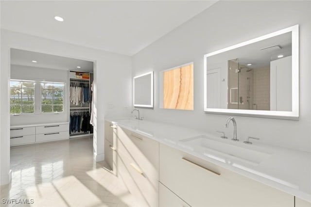 full bathroom with recessed lighting, a sink, a shower stall, double vanity, and a walk in closet