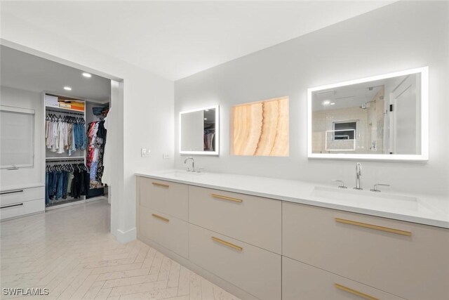 full bath with double vanity, a walk in closet, and a sink