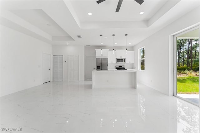 unfurnished living room featuring visible vents, a raised ceiling, a ceiling fan, marble finish floor, and recessed lighting