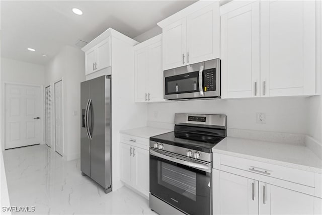 kitchen featuring appliances with stainless steel finishes, recessed lighting, marble finish floor, and white cabinetry