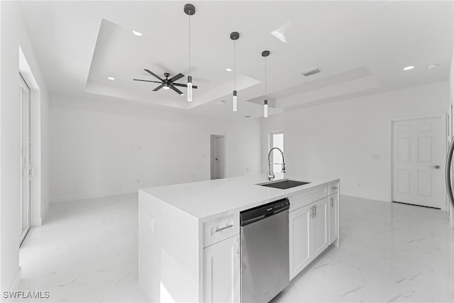 kitchen with a sink, marble finish floor, a tray ceiling, and dishwasher