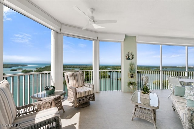 sunroom / solarium with ceiling fan and a water view