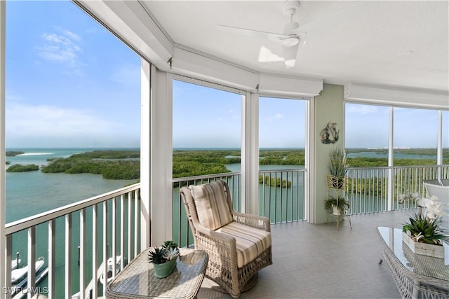 sunroom / solarium with a water view and ceiling fan