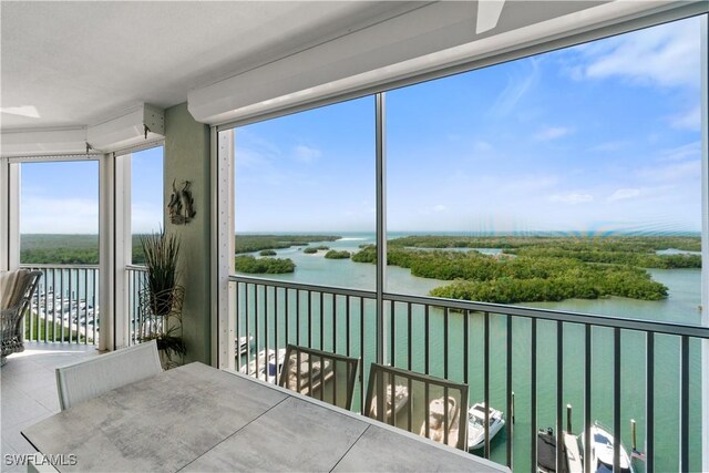 sunroom featuring a water view