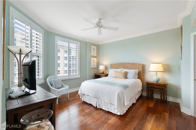 bedroom featuring a ceiling fan, crown molding, baseboards, and wood finished floors