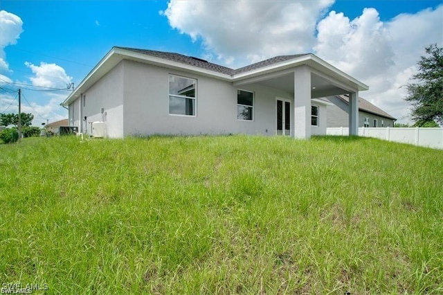 rear view of property with fence and stucco siding