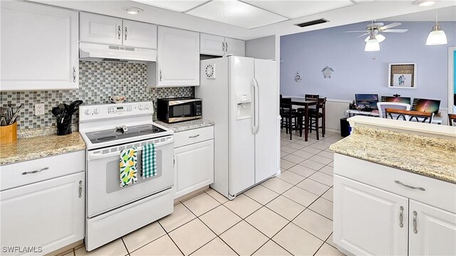 kitchen with a ceiling fan, under cabinet range hood, white appliances, light tile patterned flooring, and white cabinets