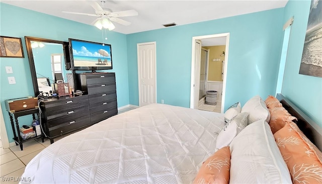 bedroom featuring light tile patterned floors, a closet, ceiling fan, and ensuite bathroom