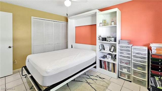 tiled bedroom featuring a closet, baseboards, and ceiling fan