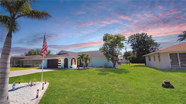 ranch-style house with a garage, driveway, and a front lawn