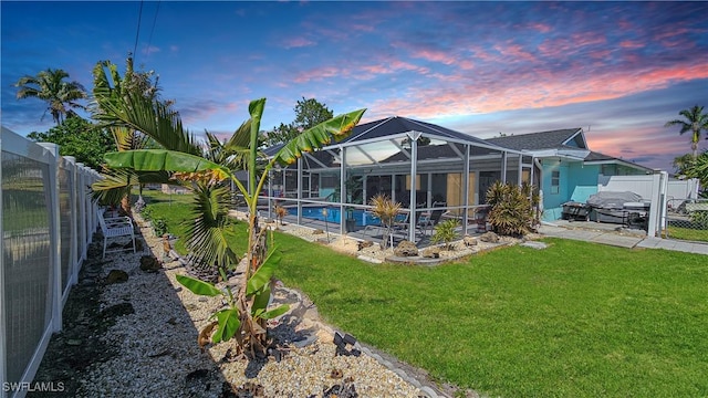 exterior space featuring a lanai, a patio, a lawn, and a fenced backyard