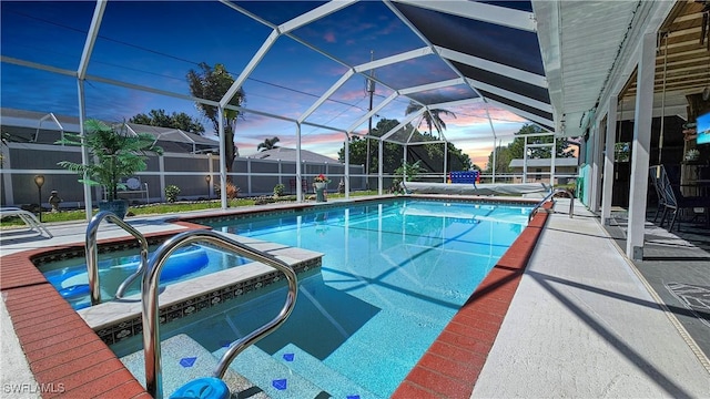 pool at dusk featuring a patio, a lanai, a fenced in pool, and a hot tub