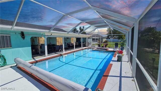 view of swimming pool with a patio area, a pool with connected hot tub, and a lanai