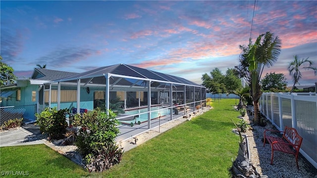 pool featuring a lanai, a fenced backyard, and a lawn