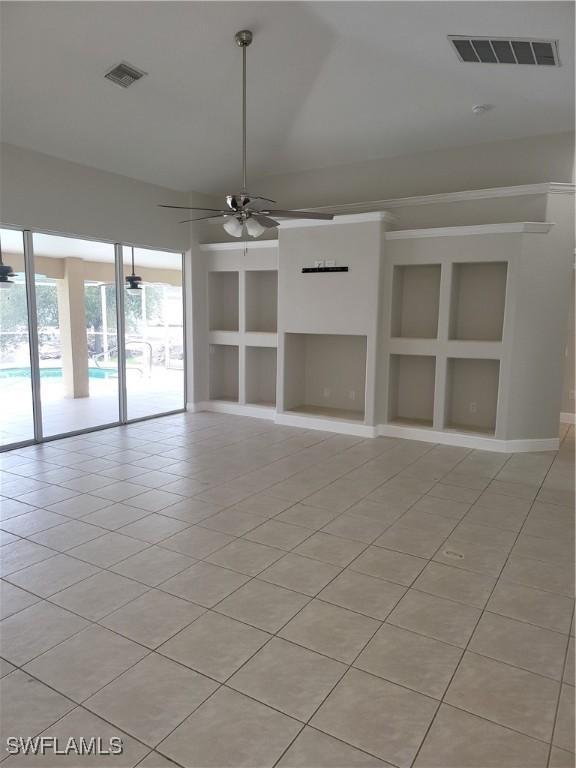 unfurnished room with built in shelves, visible vents, ceiling fan, and light tile patterned floors