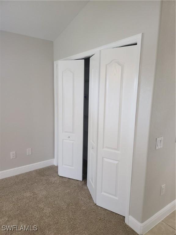 unfurnished bedroom featuring carpet floors, baseboards, and a closet